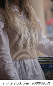 Close up unrecognizable girl wearing knitted vest, fashionable autumn-winter 2021 outfit on a rainy day outdoor.