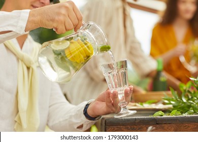 Close up of unrecognizable man pouring lemonade into glass cup while enjoying outdoor party in Summer, copy space - Powered by Shutterstock