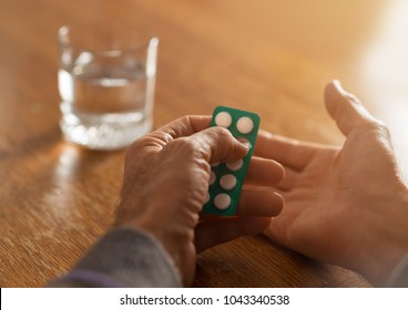 Close Up Of Unrecognizable Senior Person Taking Aspirin With Glass Of Water