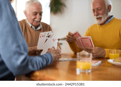 Close up of unrecognizable senior woman playing cards at home. - Powered by Shutterstock