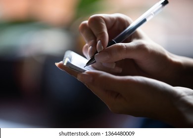 Close up unrecognizable waitress woman holds pen make notes in notepad listens client customer guest wishes cafe or restaurant visitors, girl noting creative thoughts, occupation service staff concept
