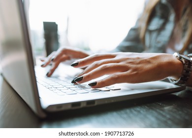 Close Up Of Unrecognizable Woman's Hands With Dark Nailpolish Using Grey Laptop Computer On Desk