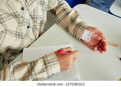 Close Up Of Unrecognizable Young Child Cheating During Test And Hiding Note In Sleeve, Copy Space