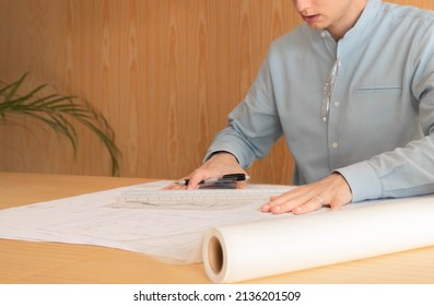 Close up of unrecognizable young man drawing on tracing paper wearing blue shirt - Shutterstock ID 2136201509