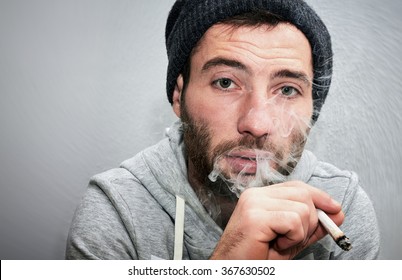 Close Up Of A Unshaven Man Smoking A Joint.