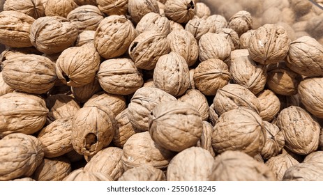 A close up of unshelled walnuts, symbolizing healthy eating and nutrition, ideal for promoting Thanksgiving recipes and autumn harvests - Powered by Shutterstock