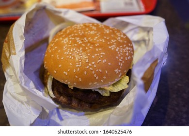 Close Up Of Unwrapped Real Cheeseburger                          