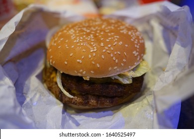 Close Up Of Unwrapped Real Cheeseburger                          