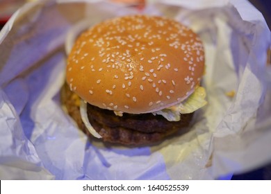 Close Up Of Unwrapped Real Cheeseburger                          