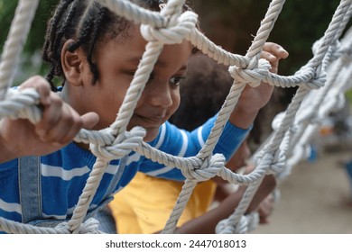 Close up, African child boy climbing a rope ladder, selective focus - Powered by Shutterstock