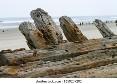 Close up, aged wooden shipwreck hull on beach.