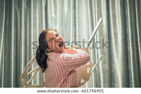 Close up, angry woman throwing a chair