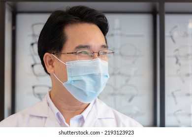 Close Up, Asian Man Professional Optician Selling Wear Protective Face Mask Selective Of Glasses In Optical Shop.