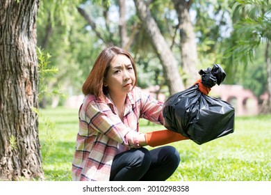 Close Up, Beautiful Asian Woman Keep Water Bottles On Green Grass At The Public Park. Recycled Waste Or Garbage Can Be Sold And Re-use. Places To Reduce Plastic Use