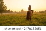 CLOSE UP: Beautiful young Caucasian blonde girl bareback riding mighty brown horse on vast meadow field on misty morning into the sunrise. Amazing relaxing ride into golden sunset