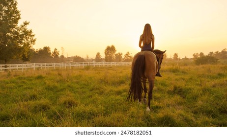 CLOSE UP: Beautiful young Caucasian blonde girl bareback riding mighty brown horse on vast meadow field on misty morning into the sunrise. Amazing relaxing ride into golden sunset - Powered by Shutterstock