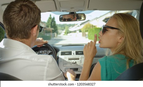 CLOSE UP: Blonde Woman Tells Her Angry Boyfriend To Be Quiet While Driving Them Home. Arguing Couple Driving In Their Car Back To Their House In The Suburbs. Frustrated Caucasian Husband And Wife.