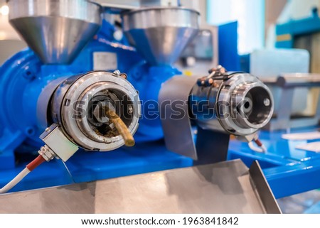 Close up: blue pet food extruder machine: mixed feed production line at factory, plant, exhibition, trade show. Farming, extrusion technology equipment, agriculture industry, animal husbandry concept