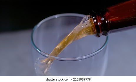 CLOSE UP, BOKEH: Detailed view of pouring fresh cold beer from bottle into the beer glass. Pouring beverage from bottle to glass in crisp details. Refreshment for summer days.