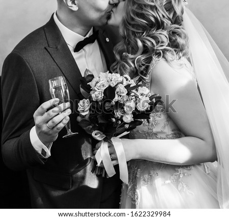 close up. bride and groom with glasses of champagne kissing each other.