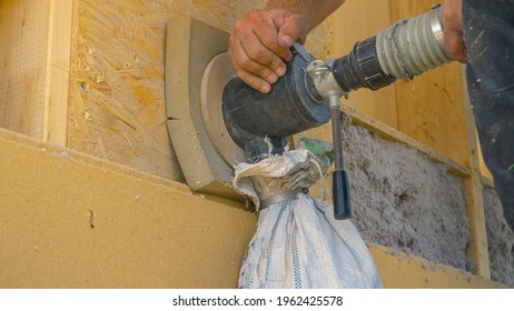 CLOSE UP: Builder Uses A Cellulose Blower To Insulate The Wood Wall With Recycled Paper. Unrecognizable Contractor Blows Cellulose Into The Wooden Walls. Worker Insulating A Modern Housing Project.