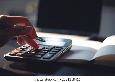 Close up, business woman working at office, using calculator to calculate company finance, accounting with laptop computer on table, budget management. Doing finance, budgeting and tax calculation