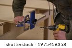 Close up. Carpenter work in the workshop. Woodwork and furniture making concept. Carpenter in the workshop marks out and assembles parts of the furniture cabinet