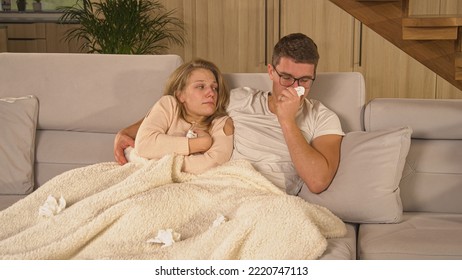 CLOSE UP: Cute Married Couple In Quarantine Due To Getting Over Covid-19 Virus. Twosome On Sick Leave And Resting On Comfy Couch At Home. Young Man And Woman Covered With Blanket And Recovering.