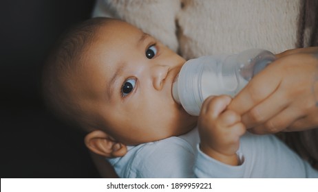 Close Up, Dark Skin Baby Drinking His Baby Milk From The Bottle. High Quality Photo