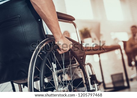 Close up. Disabled Man on Wheelchair in Office. Disabled Young Man. Man on Wheelchair. Recovery and Healthcare Concepts. Teamwork in Office. Young Workers. Sitting Man. Happy Worker.