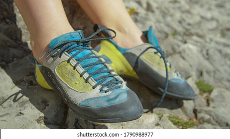 CLOSE UP, DOF: Athletic woman on rock climbing trip gets ready for her first ascent by tying her climbing shoes. Unrecognizable woman ties her climbing shoes before climbing a difficult boulder. - Powered by Shutterstock