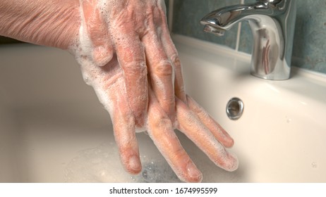 CLOSE UP, DOF: Unrecognizable Person Thoroughly Washes Their Hands With Antibacterial Soap During The Coronavirus Outbreak. Older Woman Is Washing Her Hands To Avoid The Corona Virus Infection.