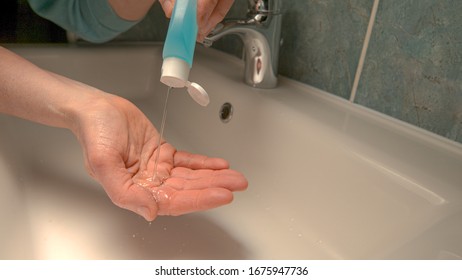 CLOSE UP, DOF: Unrecognizable Person Washes Their Hands With Alcohol Hand Sanitizer Over The Bathroom Sink. Older Man Following Covid19 Precautionary Measures Disinfects His Hands With Sanitizer