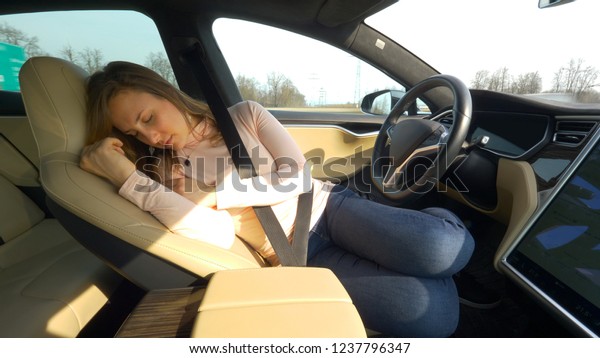 CLOSE UP: Exhausted female driver sleeps\
tightly in her car set on auto pilot. Young Caucasian woman\
enjoying a tranquil road trip by napping in a self driving vehicle.\
Tired tourist girl\
sleeping.