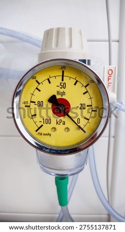 Close up, front view, OFF switch visible
Hospital wall-mounted medical suction vacuum gauge with yellow dial face showing negative pressure scale in kPa and mmHg, with red center indicator and green tubing connector. White OFF switch visible to the right. Vertical composition.