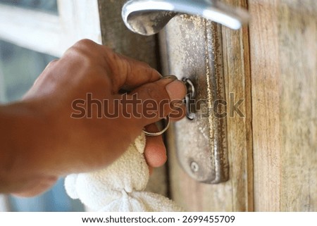 Close up, hand inserts the key into the door lock