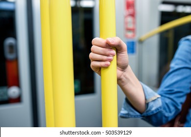 Close up, hand of unrecognizable woman in subway train