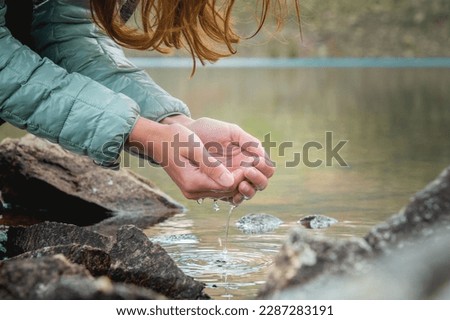 Close up, hands in the water from a glacial stream from the spring thaw. Clean refreshing drinking water in the forest. Pure water natural resources concept