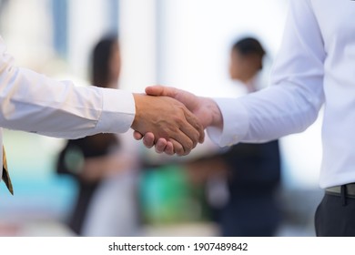 Close up, Handshake of two businessmen on the background of modern office, partnership concept, Shaking hands to seal a deal