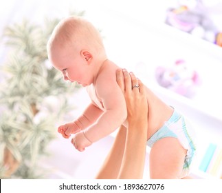 Close Up. Happy Baby In The Hands Of His Mother.