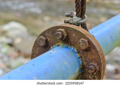 Close up, insulated old rusty steel wire rope and metal wires or ropes connected by old rusty clamps. - Shutterstock ID 2255958147