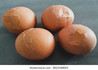 Close up, isolated example of Hardboiled eggs on a surface with the shells rolled and cracked for easy peeling. Close-up of multiple hard-boiled eggs showing the rolling method to crack shells before peeling. Hard-boiled eggs on an isolated background, rolled on a hard surface to crack the shell for easy peeling. Photo of Cooled and gently tapped hardboiled eggs showing the roll and crack technique against a clean background.