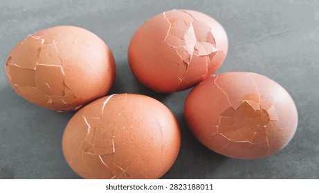 Close up, isolated example of Hardboiled eggs on a surface with the shells rolled and cracked for easy peeling. Close-up of multiple hard-boiled eggs showing the rolling method to crack shells before peeling. Hard-boiled eggs on an isolated background, rolled on a hard surface to crack the shell for easy peeling. Photo of Cooled and gently tapped hardboiled eggs showing the roll and crack technique against a clean background.