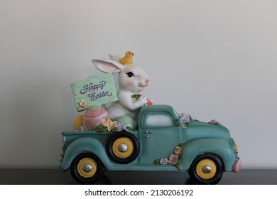 The Close Up, Isolated Image Of The Easter Bunny Driving A Blue Pick Up Truck. He Has A Chick On His Head, Colorful Eggs In The Truck's Bed, And A Sign That Reads 