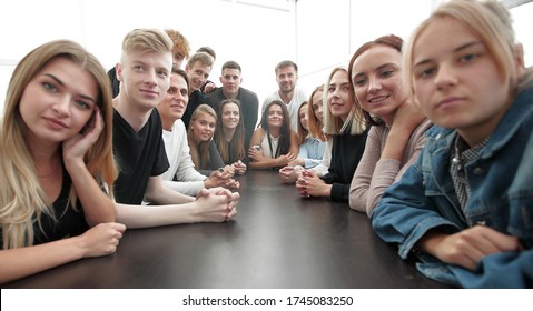 Close Up. A Large Group Of Friends Sitting At A Long Table