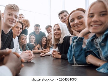 Close Up. A Large Group Of Friends Sitting At A Long Table