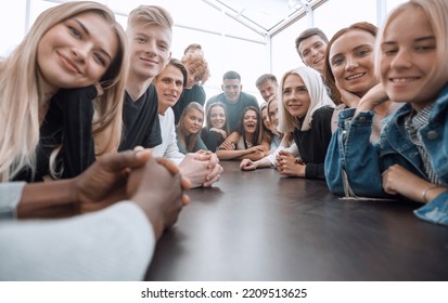 Close Up. A Large Group Of Friends Sitting At A Long Table