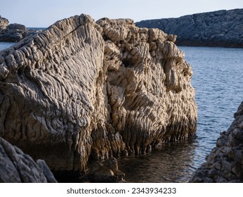 CLOSE UP: Large stone with an extremely eroded texture on coast of Adriatic Sea. Extraordinary types of rock erosion found during holiday walk along rugged rocky coastline on beautiful island of Hvar. - Powered by Shutterstock