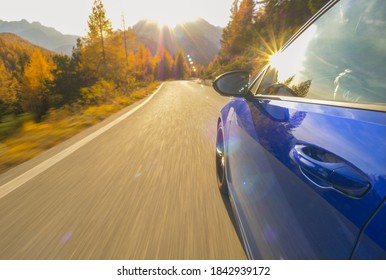 CLOSE UP, LENS FLARE: Idyllic view of sunlit Dolomites as blue sportscar drives down scenic road. Cinematic shot of golden sunbeams reflecting in the shiny door of a car cruising down mountain road. - Shutterstock ID 1842939172