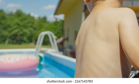 CLOSE UP: Little Boy's Back With Applied Sunscreen For Sunburn And UV Protection. Appliance Of Sun Protection Cosmetics To Sensitive Skin Of Boy Toddler For Carefree Holidays In Sunny Summer Season.